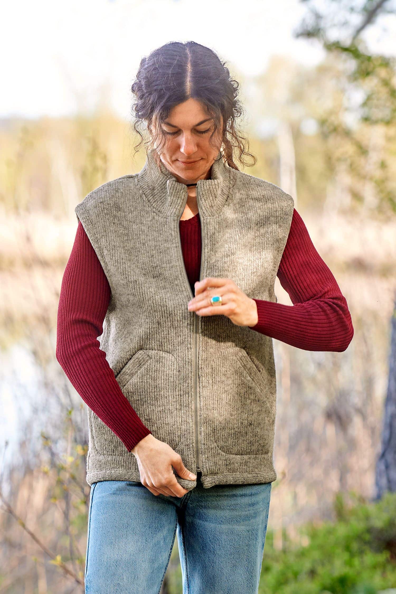 Frau trägt die graue ungefärbte Finkhof Wollwalkweste aus bio Wolle (kbT) ohne Ärmel mit rotem Shirt