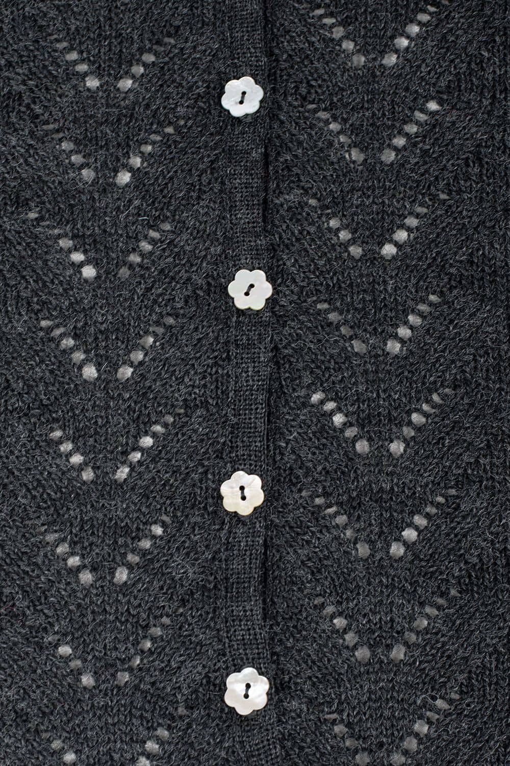 Detailfoto von grauem Cardigan mit Ajourmuster aus bio Wolle (kbT) mit blumenförmigen Knöpfen