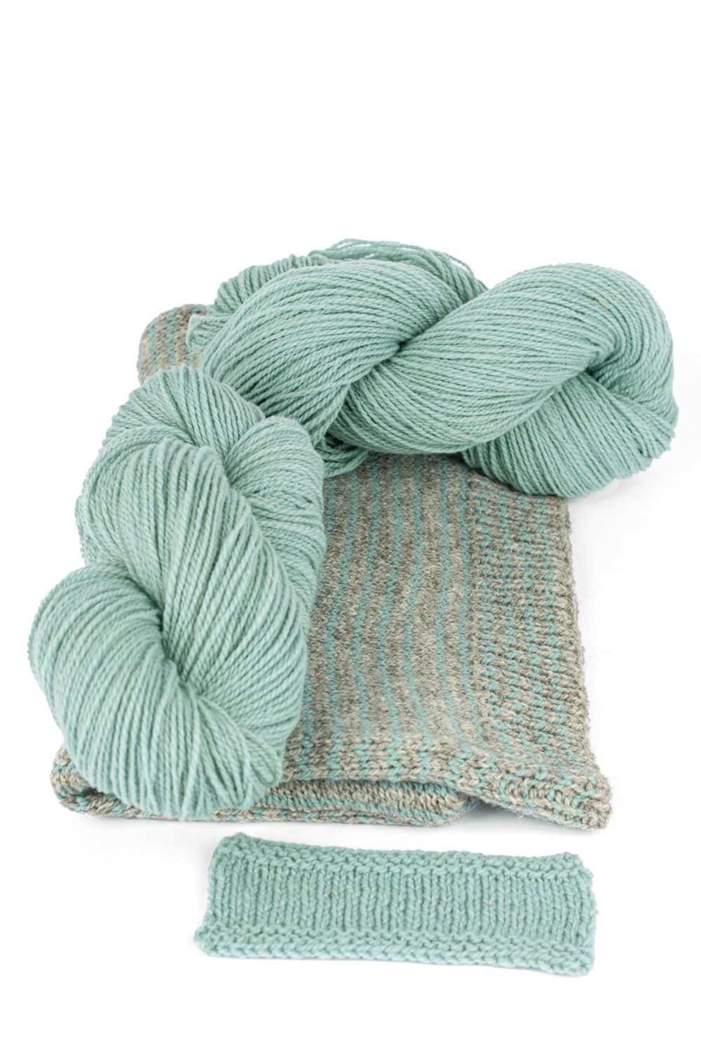 Finkhof Merinowolle dick gefärbt pastellblau dicke pastellblaue Finkhof Merinowolle aus bio Wolle (kbT) mit Strickstück davor, weißer Untergrund