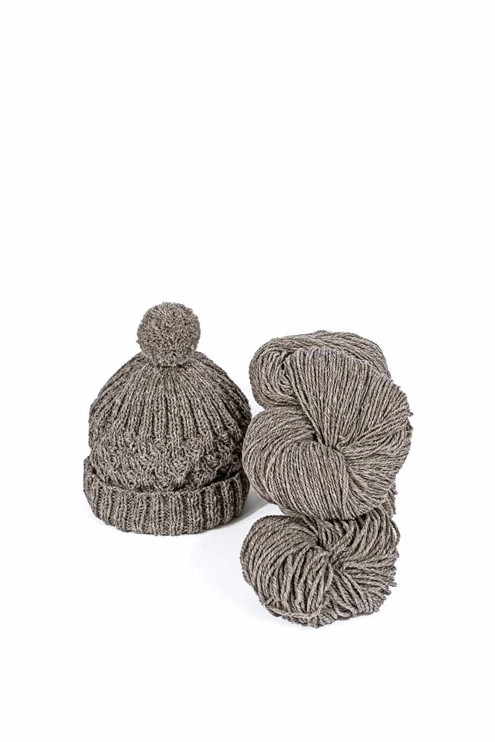 dünne ungefärbte bio (kbT) Merinowolle vom Finkhof als Strang in dunkelgrau mit Beispiel einer gestrickten Mütze