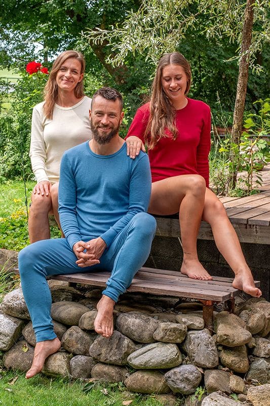 Wollhemd Langarm unisex Mann und Frauen im Garten tragen Wollunterwäsche darunter ein langarm Wollhemd aus bio Wolle (kbT) in rot, weiß und blau