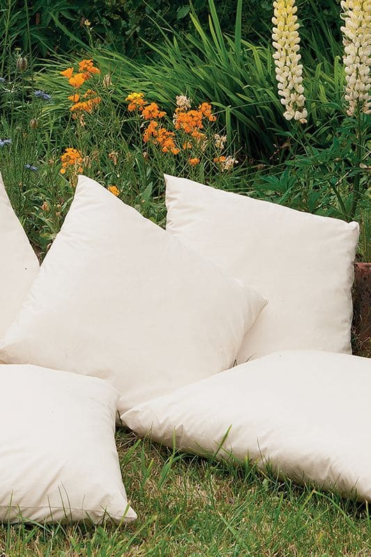 weiße quadratische Finkhof Sofakissen in 40x40 cm auf Wiese aus bio Wolle (kbT) und bio Baumwolle (kbA)