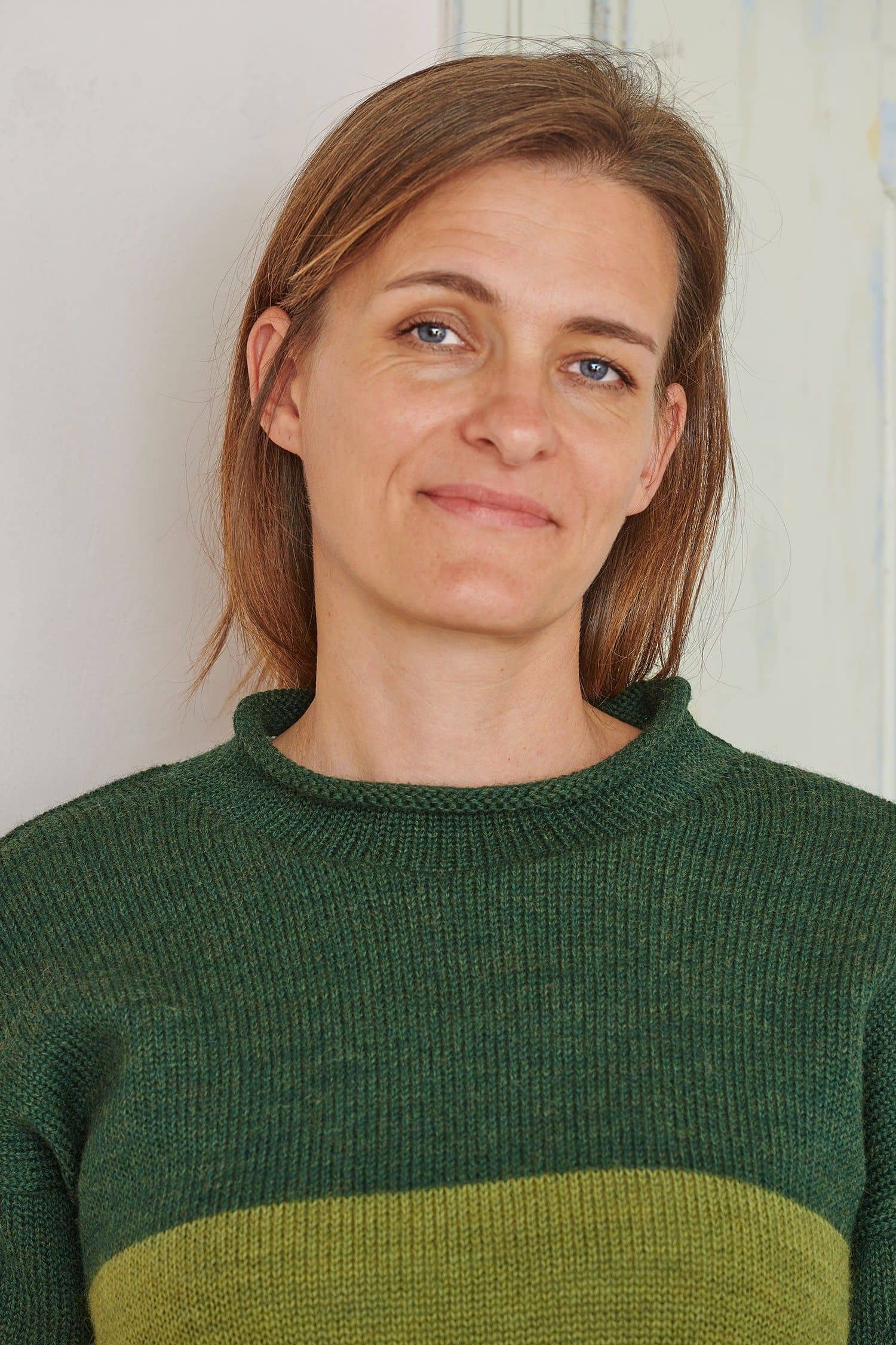 Portraitaufnahme von Frau mit grünem Streifenpullover aus bio Wolle (kbT)