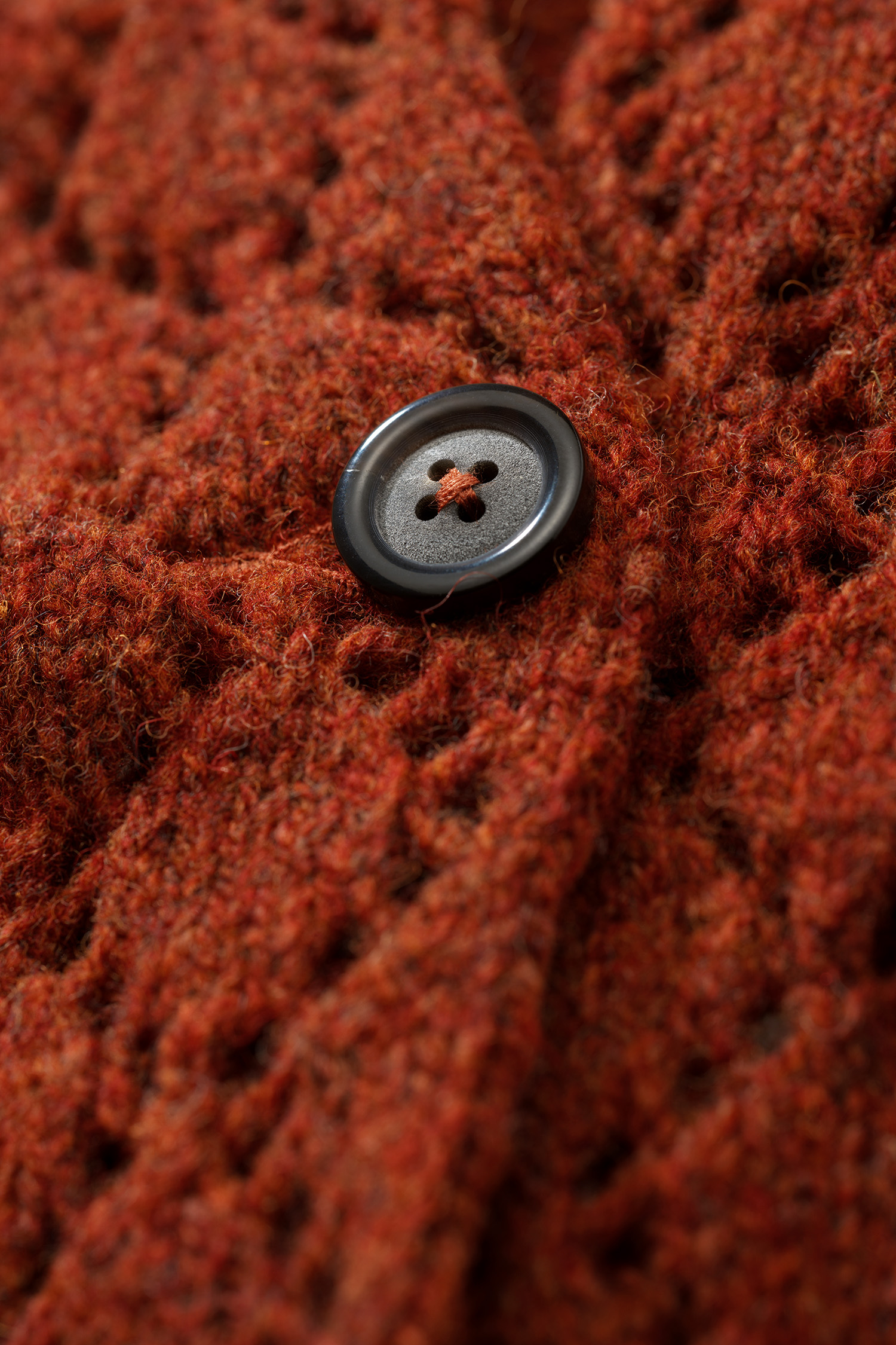 Nahaufnahme der Bündchen der rot orangen Strickjacke mit Ajourmuster aus Bio-Wolle vom Finkhof