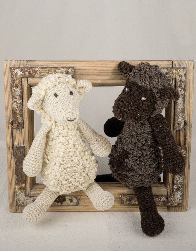 helles und dunkles Schaf sitzen in Holzrahmen