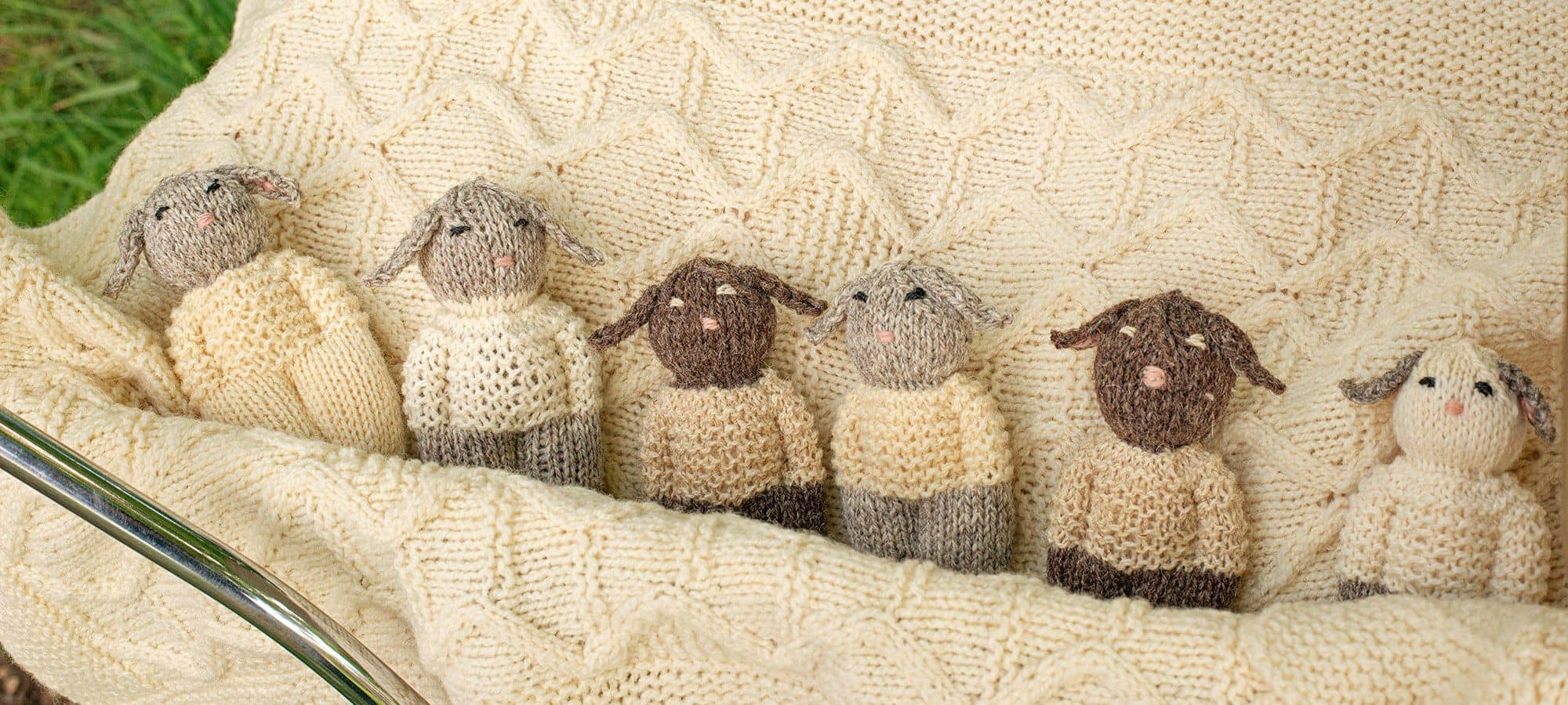 Strickanleitung Schlafschafe kleine Strickschafe liegen in Strickdecke als Beispiel für das Buch ,, Stricken für die Kleinsten"