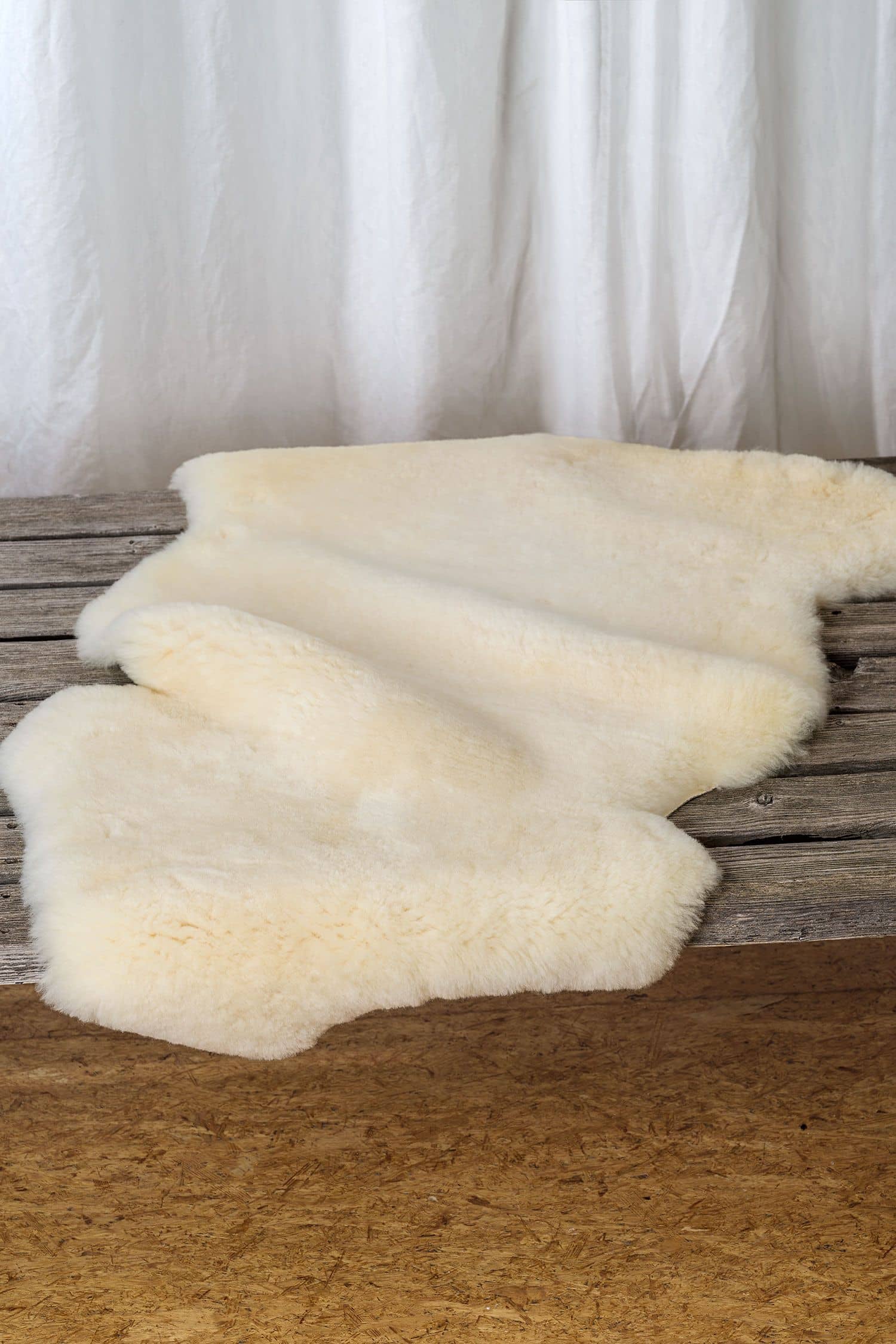 weißes pflanzlich gegerbtes Finkhof Schaffell auf einer braunen Bank