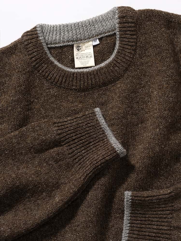 Kragen und Ärmelbündchen des brauen ungefärbten Finkhof Pullis aus bio Wolle (kbT)