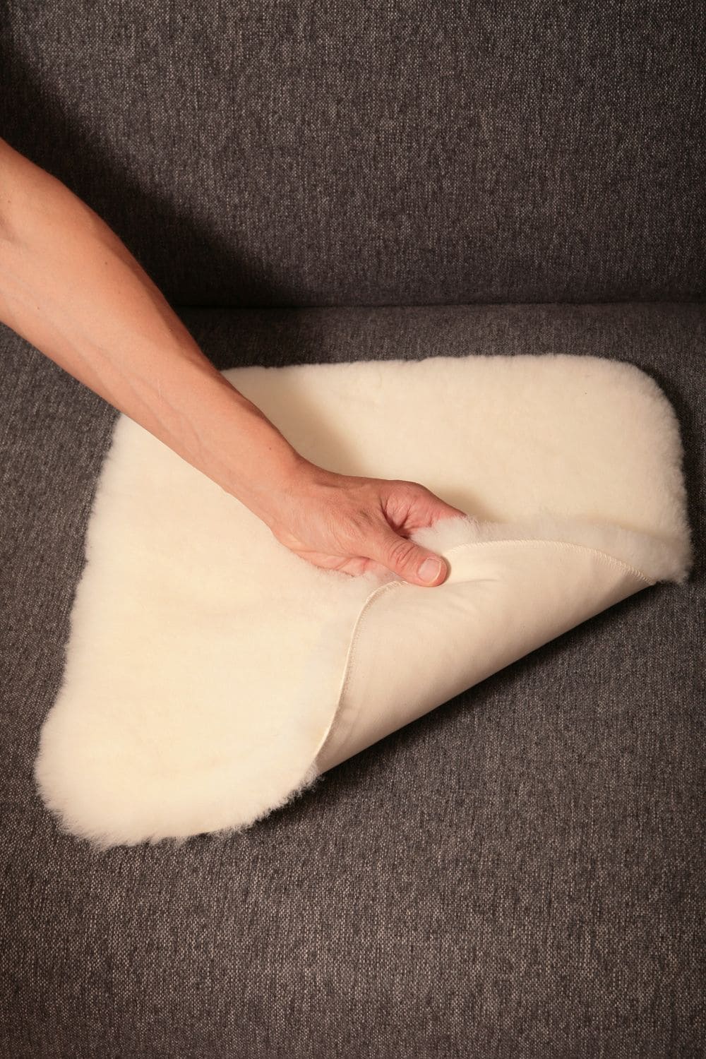 pflanzlich gegerbte weiße Fellauflage auf grauem Sofa