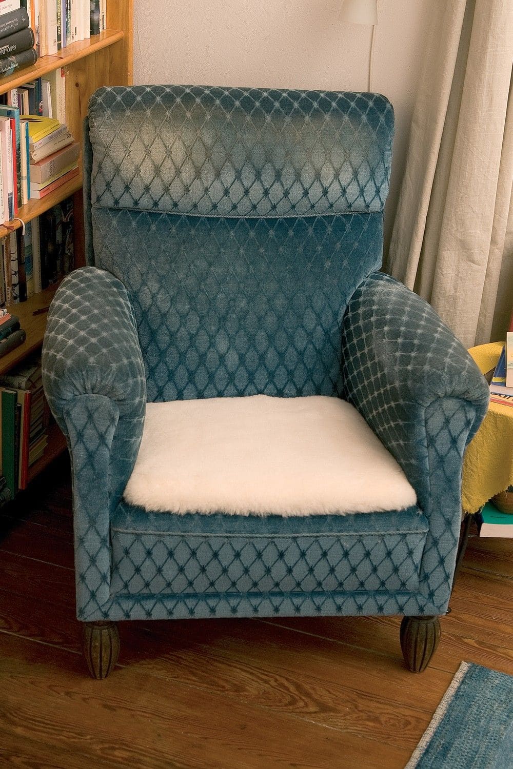 blauer Sessel mit weißer Fellauflage