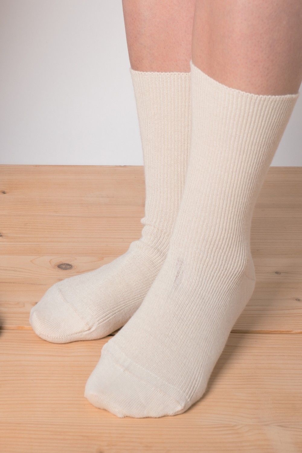 Venensocken aus Schurwolle und Bio-Baumwolle Model trägt naturweiße Venensocken aus bio Baumwolle (kbA) und Wolle