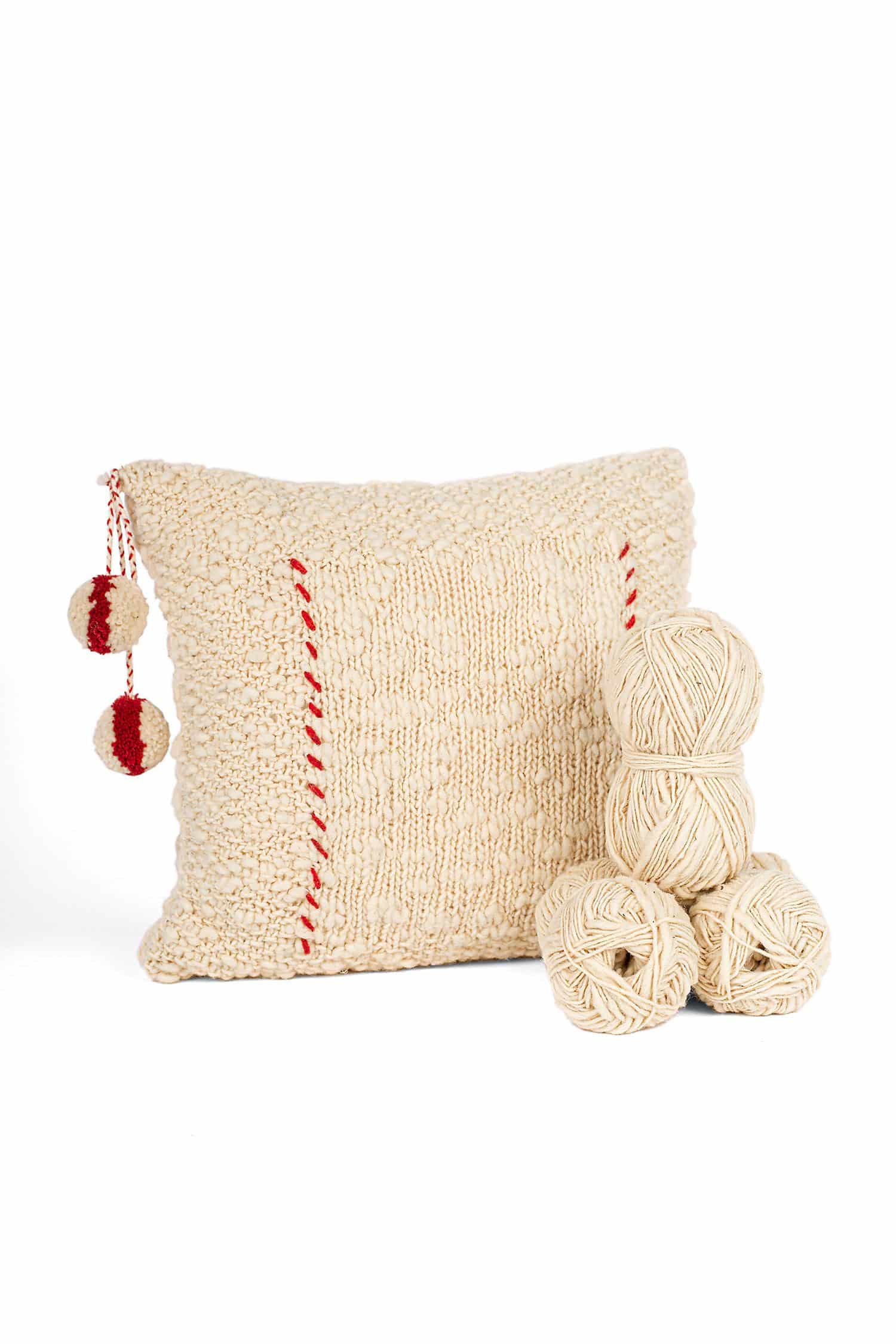Kissenbezug aus Flammengarn mit roten Details und Wollknäulen