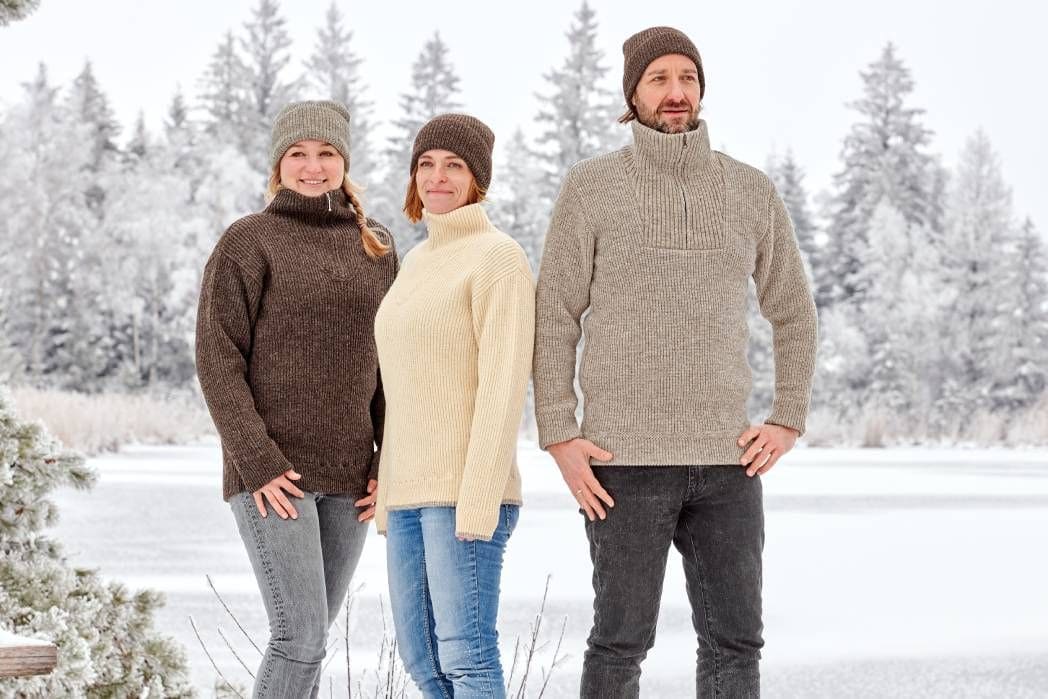 Personen mit Finkhof Troyern und Mützen aus bio Wolle (kbT) in winterlicher Landschaft