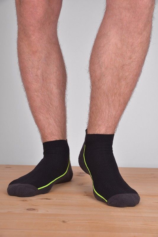kurze grün/graue Sportsocken aus bio Baumwolle (kbA), Polyamid und Elasthan, getragen auf Holzboden von vorne