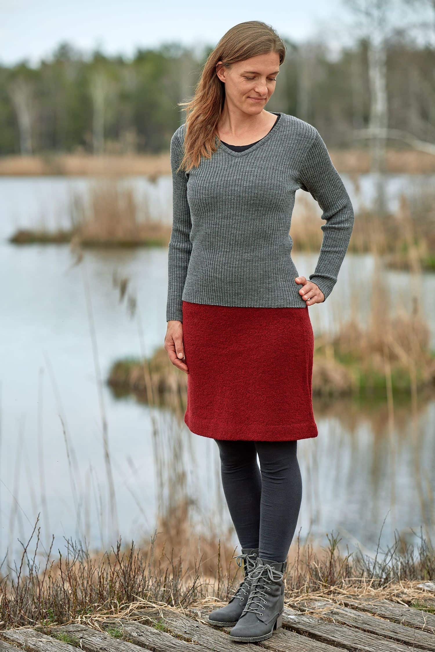 Frau mit grauem Rippshirt trägt einen roten Wollkrepprock aus bio Wolle (kbT)