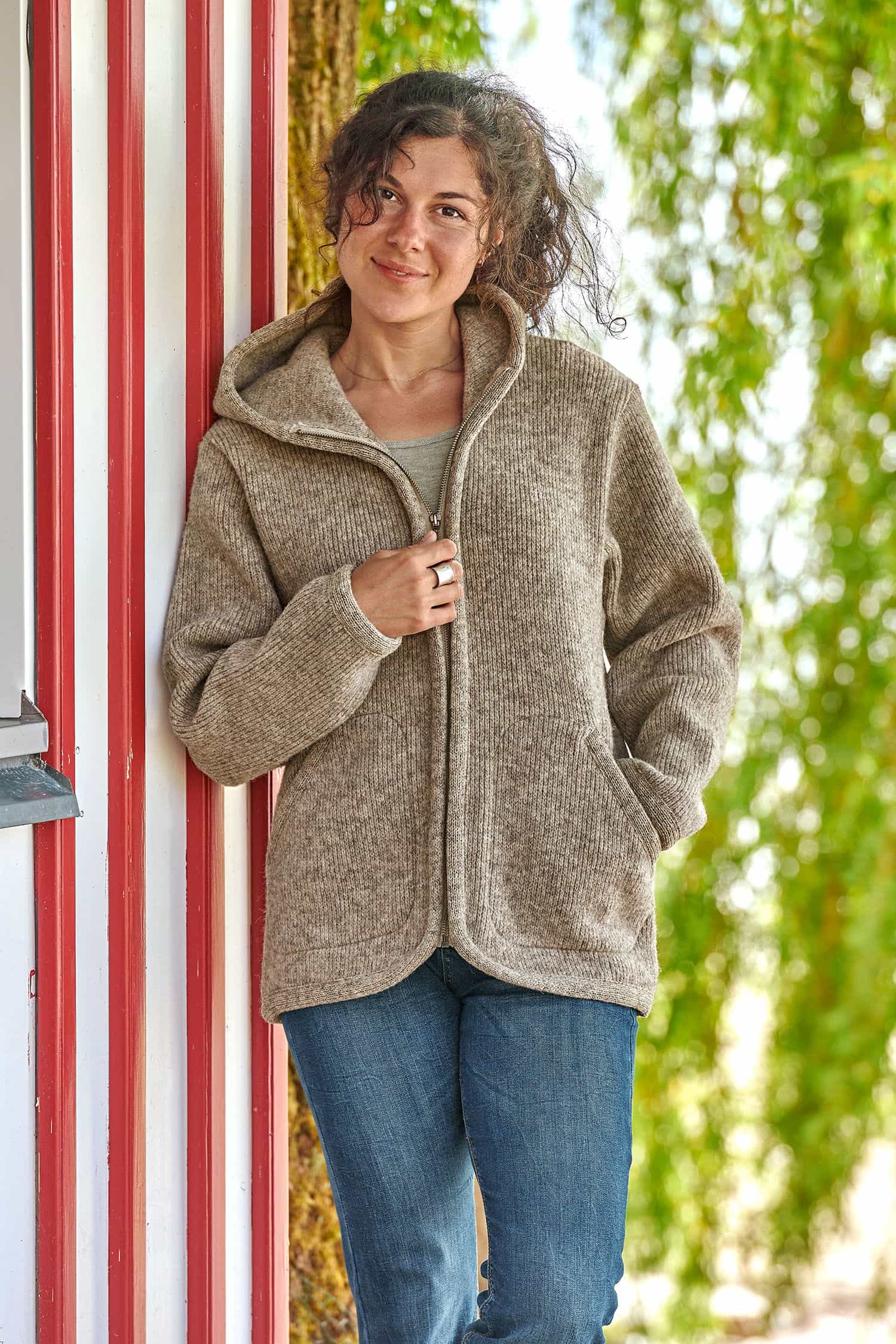 Frau trägt eine graue Kapuzenjacke vom Finkhof aus Walkstoff mit bio Wolle (kbT) vom Finkhof