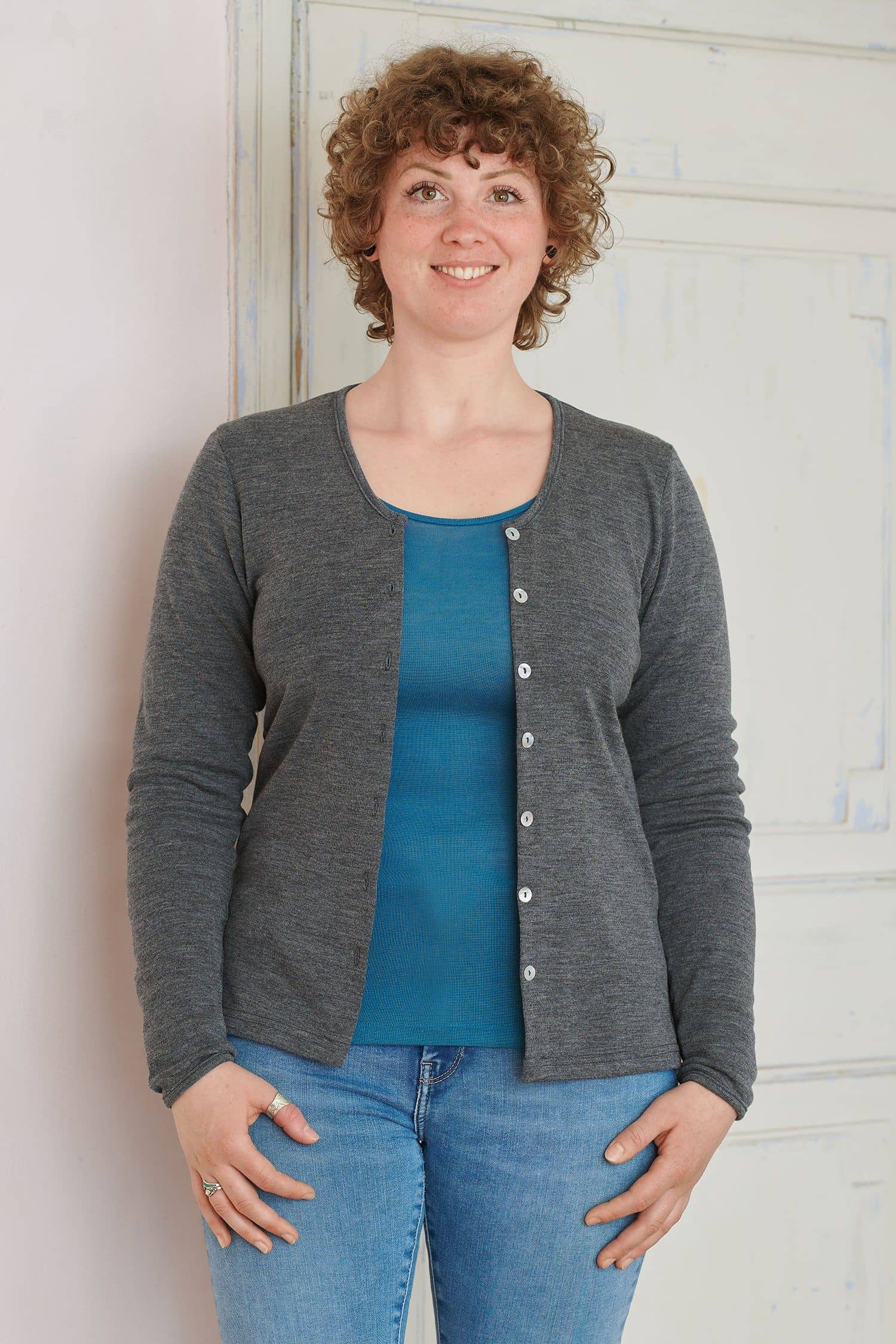 Frau trägt ein blaues Shirt und einen grauen Cardigan aus bio Wolle (kbT)