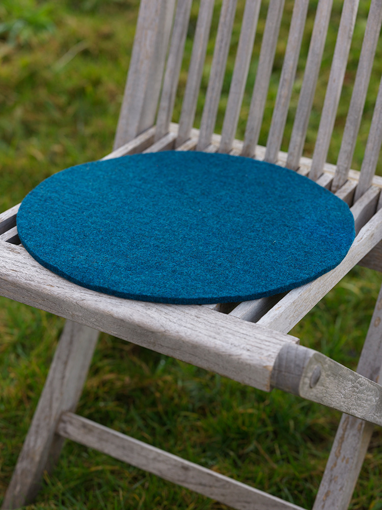 blaue runde Finkhof Sitzauflage aus bio Wolle (kbT) auf einem Gartenstuhl