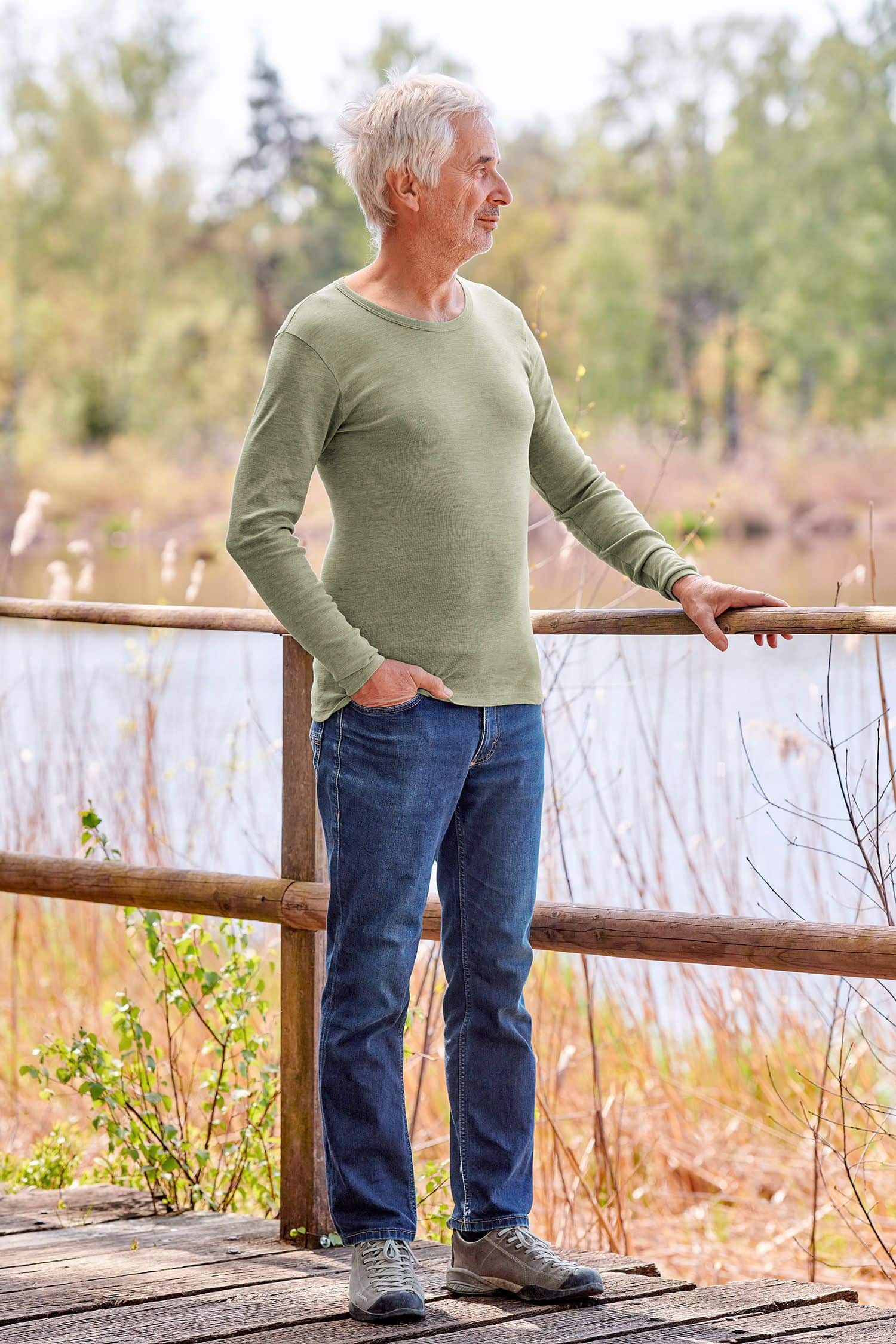 Mann mit Jeans trägt grünes Langarmshirt aus bio Wolle (kbT), bio Baumwolle (kbA) und Seide