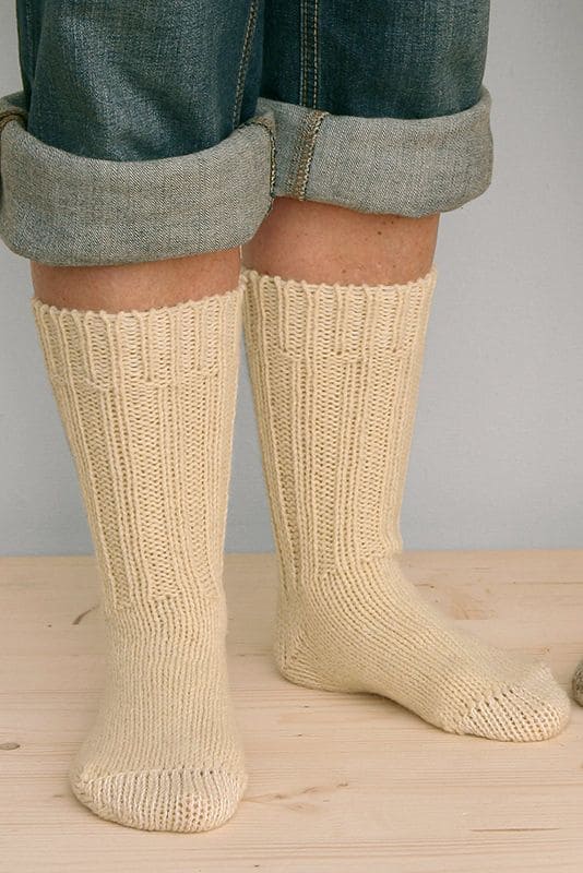 Dicke Finkhof-Socken naturweiß Gr. 36/37 Person mit hochgekrempelter Jeans trägt naturweiße dicke Finkhof Socken aus bio Wolle (kbT)