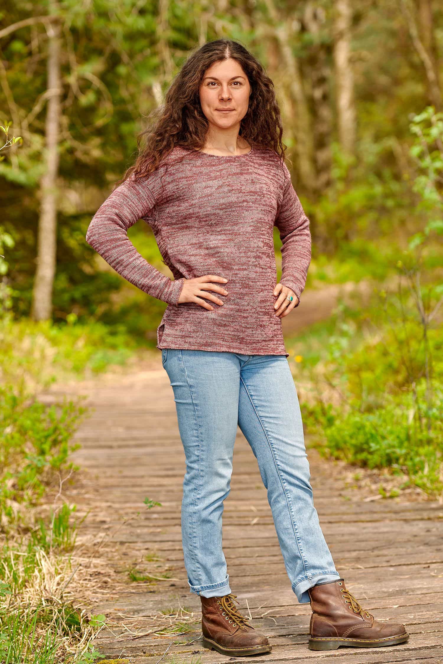 Frau mit Jeans trägt rosamelierten Strickpullover aus bio Baumwolle (kbA) und bio Wolle (kbT)