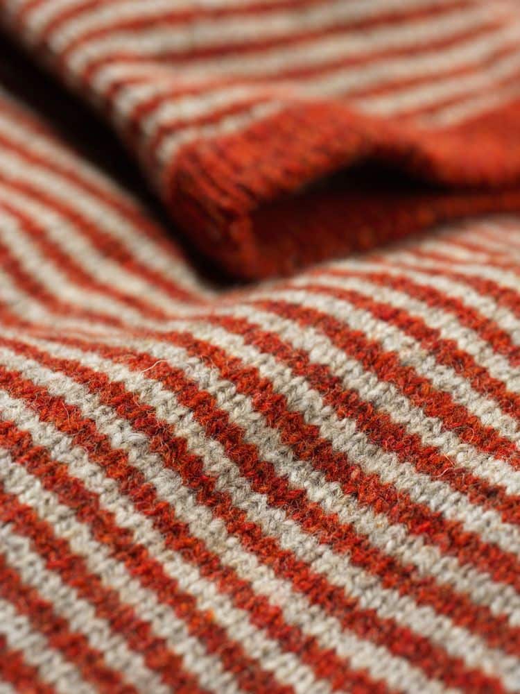 Detailaufnahme der Stoffstruktur des rot weiß gestreiften Pullis aus bio Wolle (kbT) vom Finkhof