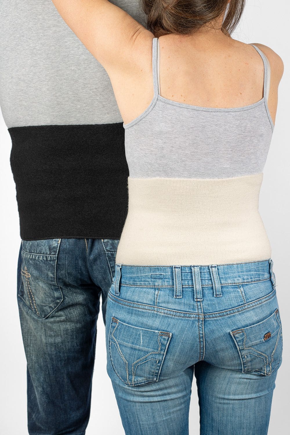 Nierenwärmer warm Mann und Frau von hinten mit Jeans, grauem Top und leichtem Nierenwärmer in schwarz und naturweiß