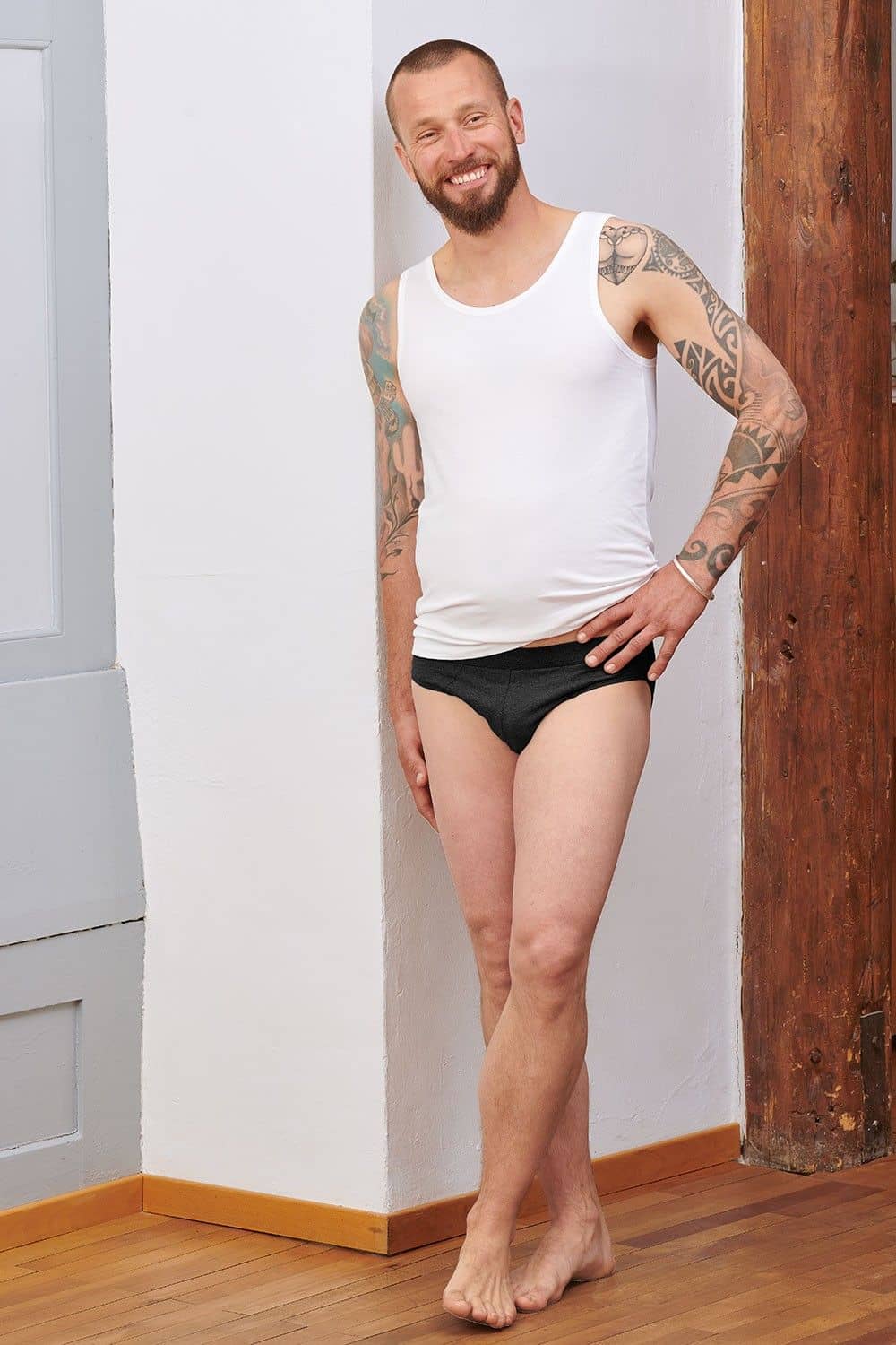 Mann mit weißem Top trägt schwarzen Slip aus bio Baumwolle (kbA) und Elasthan