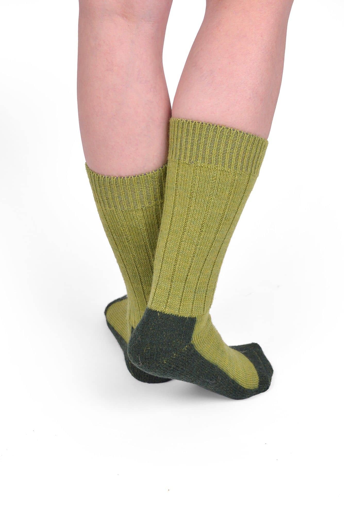 Person trägt grüne Trekking-Socken aus bio Wolle (kbT) und bio Baumwolle (kbA), von hinten