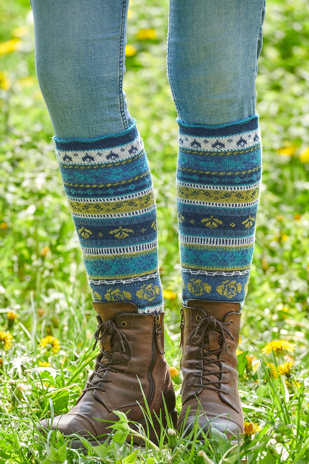 blau grün gemusterte Beinstulpen aus bio Wolle (kbT) mit braunen Stiefeln, Freisteller
