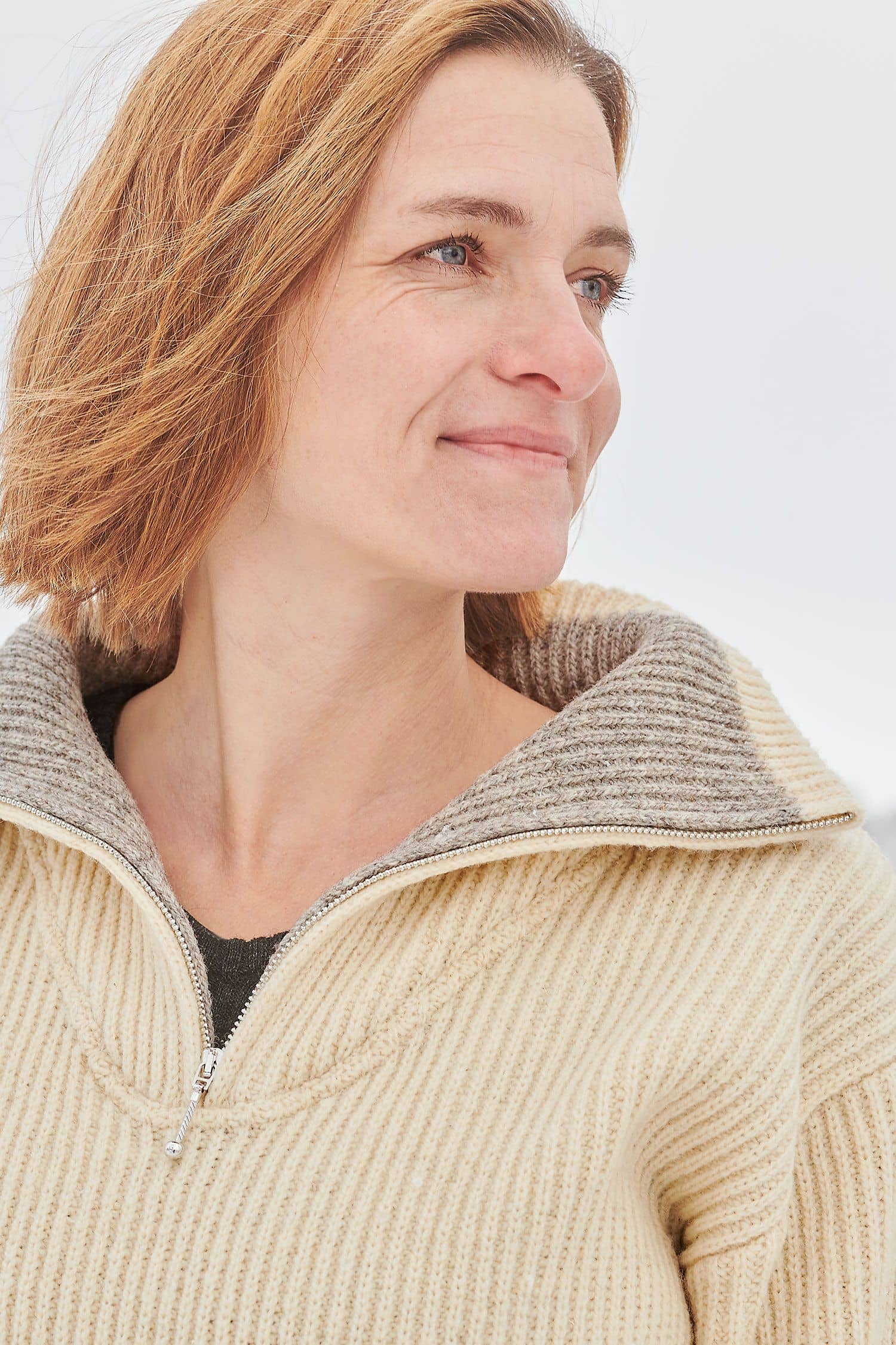 Portraitaufnahme von Frau mit naturweißem Finkhof Troyer aus bio Wolle (kbT)