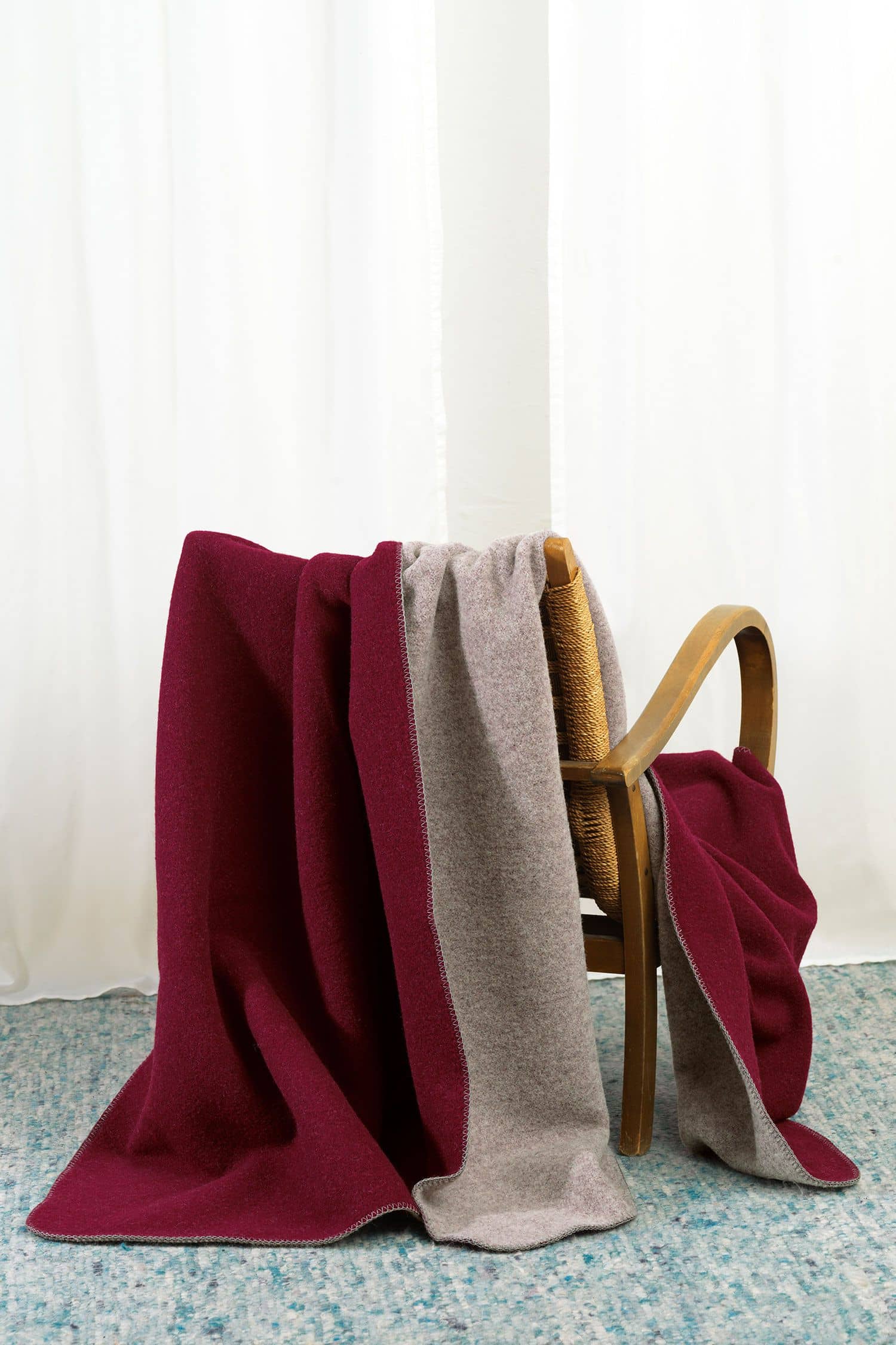 Finkhof-Wolldecke Doubleface burgund/grau 150 x 200 cm Finkhof Wolldecke Doubleface aus bio Wolle (kbT) vom Merinolandschaf in burgunderrot grau über Stuhllehne gehängt
