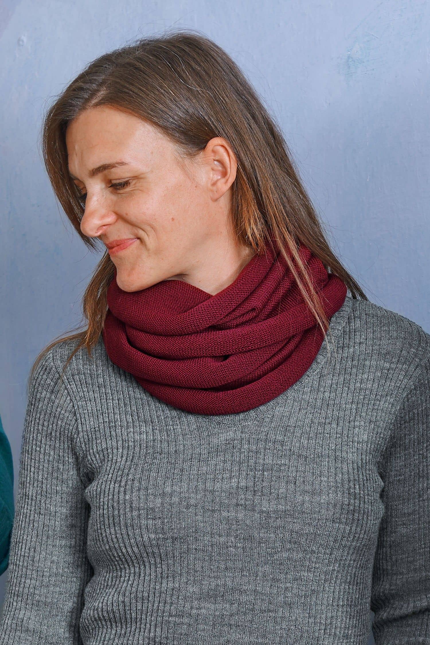 Frau mit grauem Rippshirt trägt bordeauxroten Schlauchschal aus bio Wolle (kbT) vom Finkhof