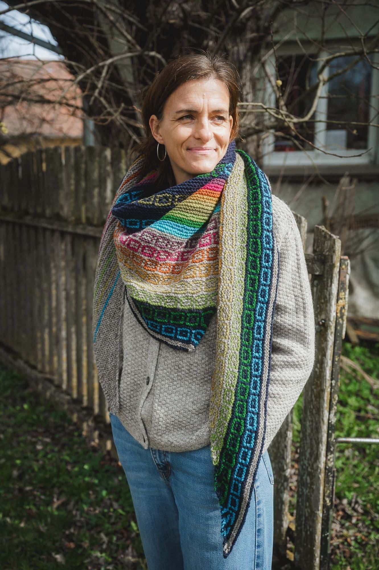 Frau trägt regenbogenfarbener Schal mit grauer Strickjacke vom Finkhof