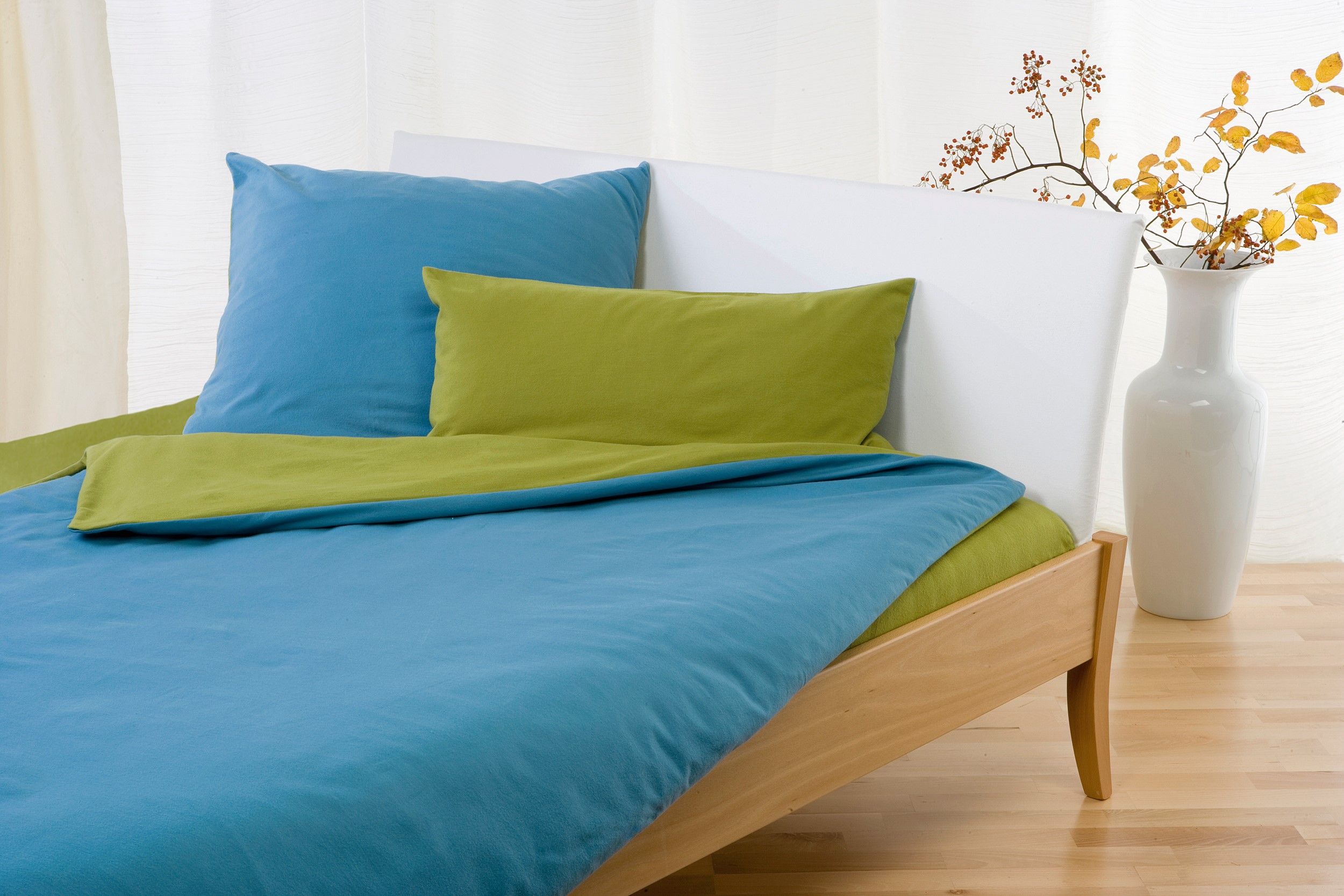 blau grüne Wendebettwäsche aus bio Baumwolle (kbA) auf weißem Bett