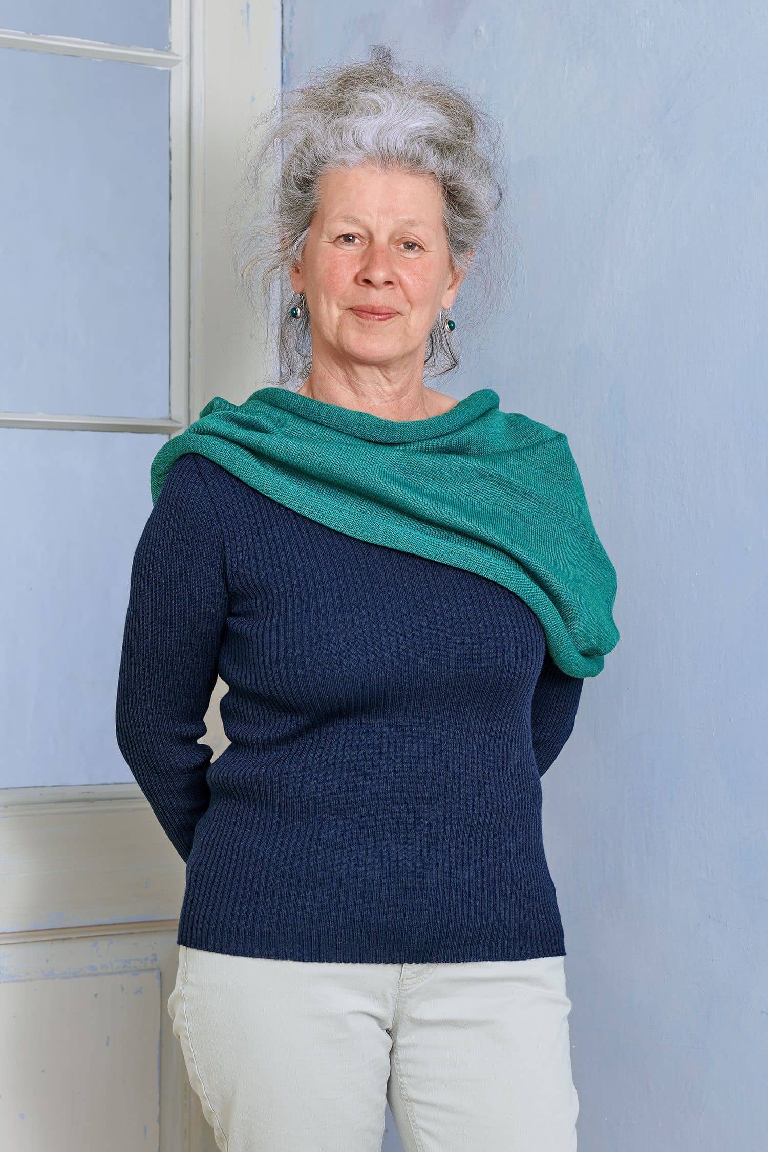 Schlauchschal türkis Frau mit blauem Rippshirt hat türkisen Schlauchschal aus bio Wolle (kbT) vom Finkhof um die Schultern