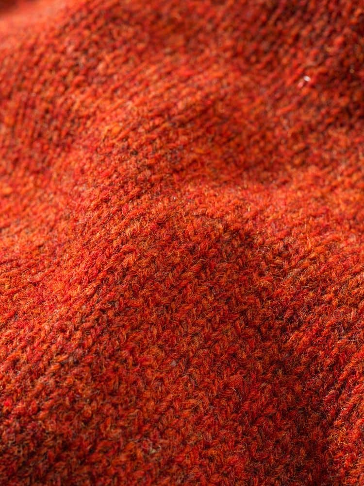 Detailaufnahme der Stoffstruktur des roten Finkhof Kapuzenpullis aus bio Merinowolle (kbT)