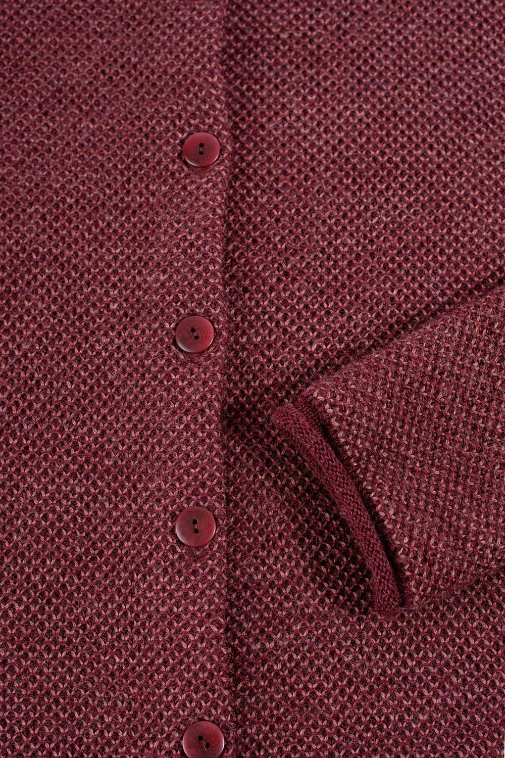 Detailfoto von den Knöpfen einer burgunderfarbenen Strickjacke