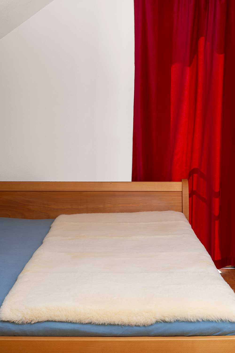 rechteckige relugan gegerbte Finkhof Felldecke auf Holzbett mit blauem Laken