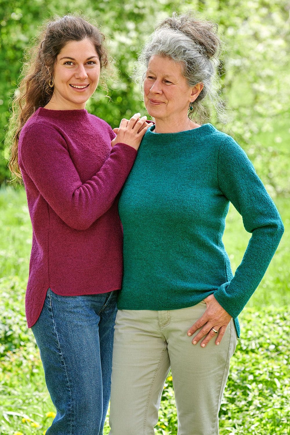 Pulli Frieda Frauen tragen fuchsiafarbenen und türkisen Pullover aus bio Wolle (kbT) und lehnen sich dabei aneinander