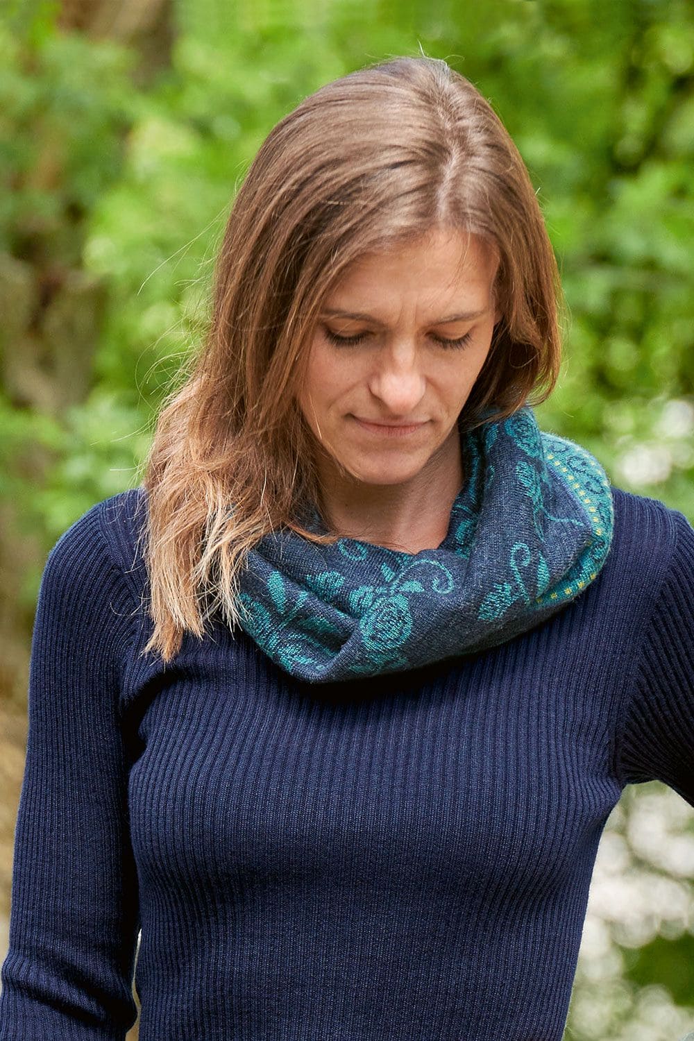 Loop Rose nachtblau Loop Rose nachtblau aus bio Wolle (kbT) an weiblichem Model mit blauem Strickpulli in der Natur