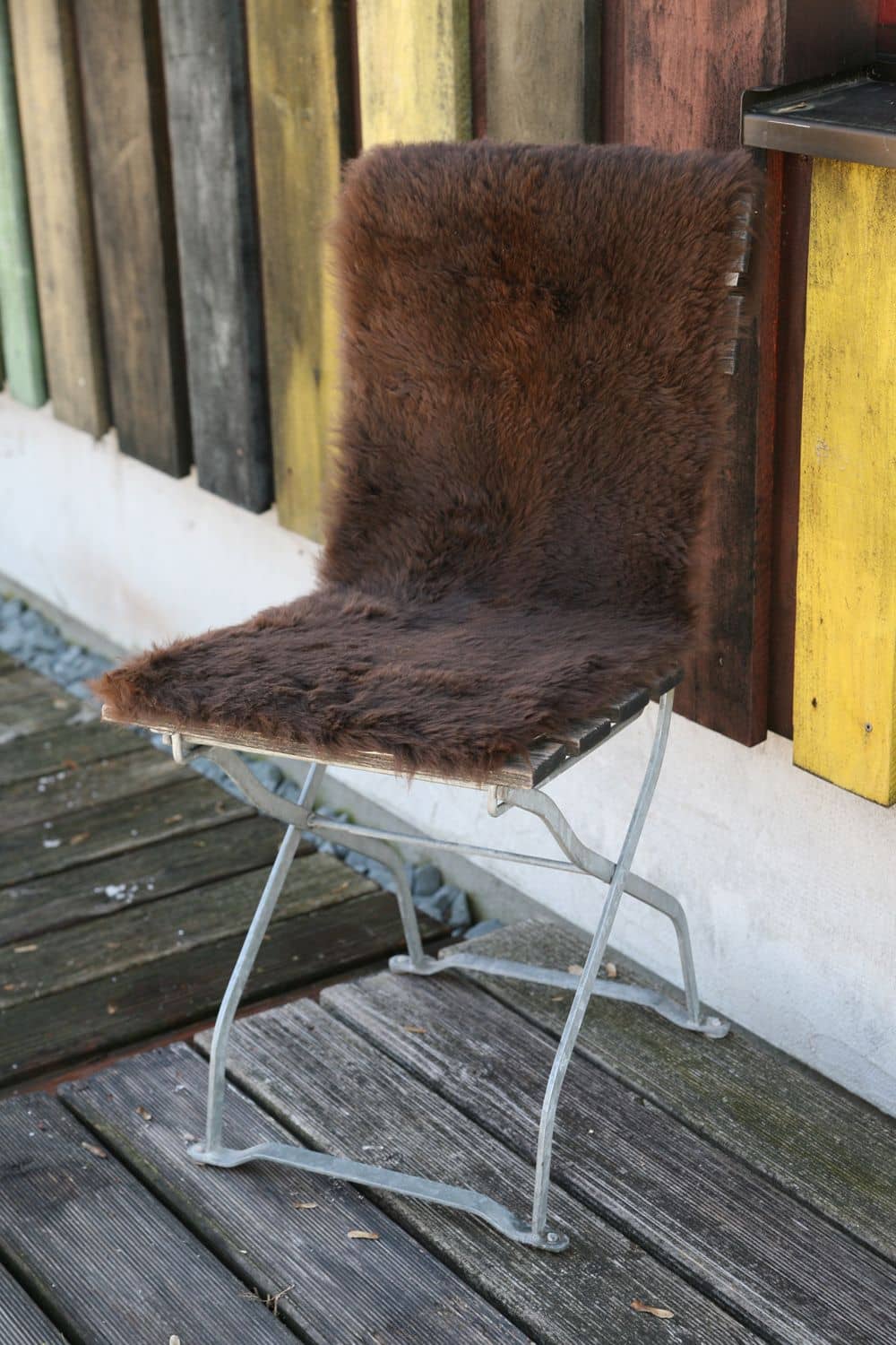 braune Bankfellauflage aus pflanzlich gegerbtem Schaffell vom Finkhof auf einem Stuhl