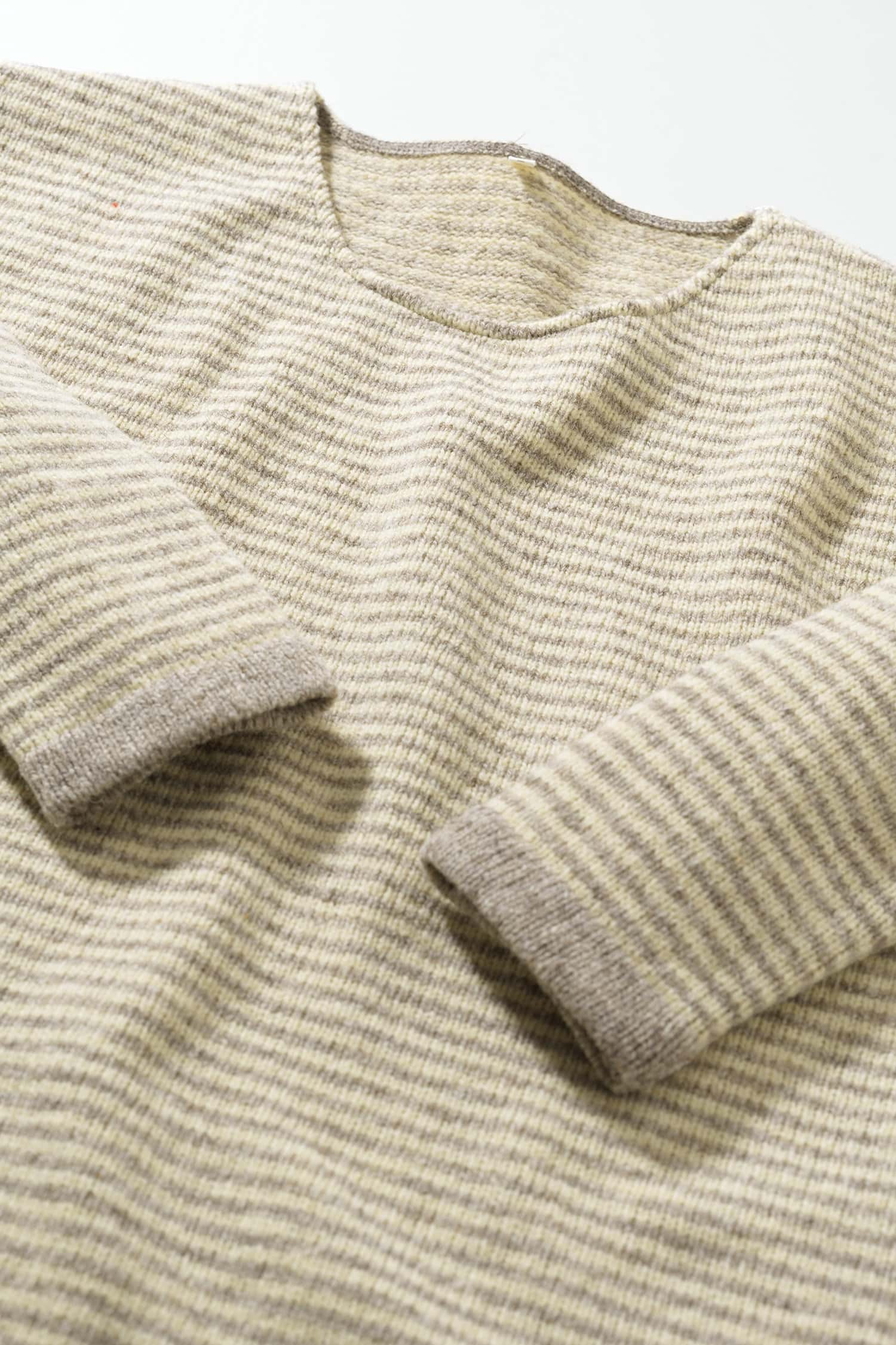 Nahaufnahme der Bündchen des weiß grau geringelten Pullovers aus Bio-Schurwolle vom Finkhof