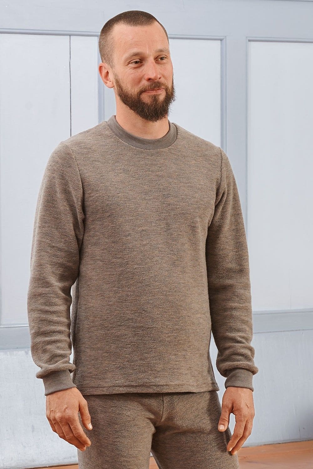 Mann trägt walnussbraunes Wollfrotte-Schlafanzugoberteil aus bio Wolle (kbT)