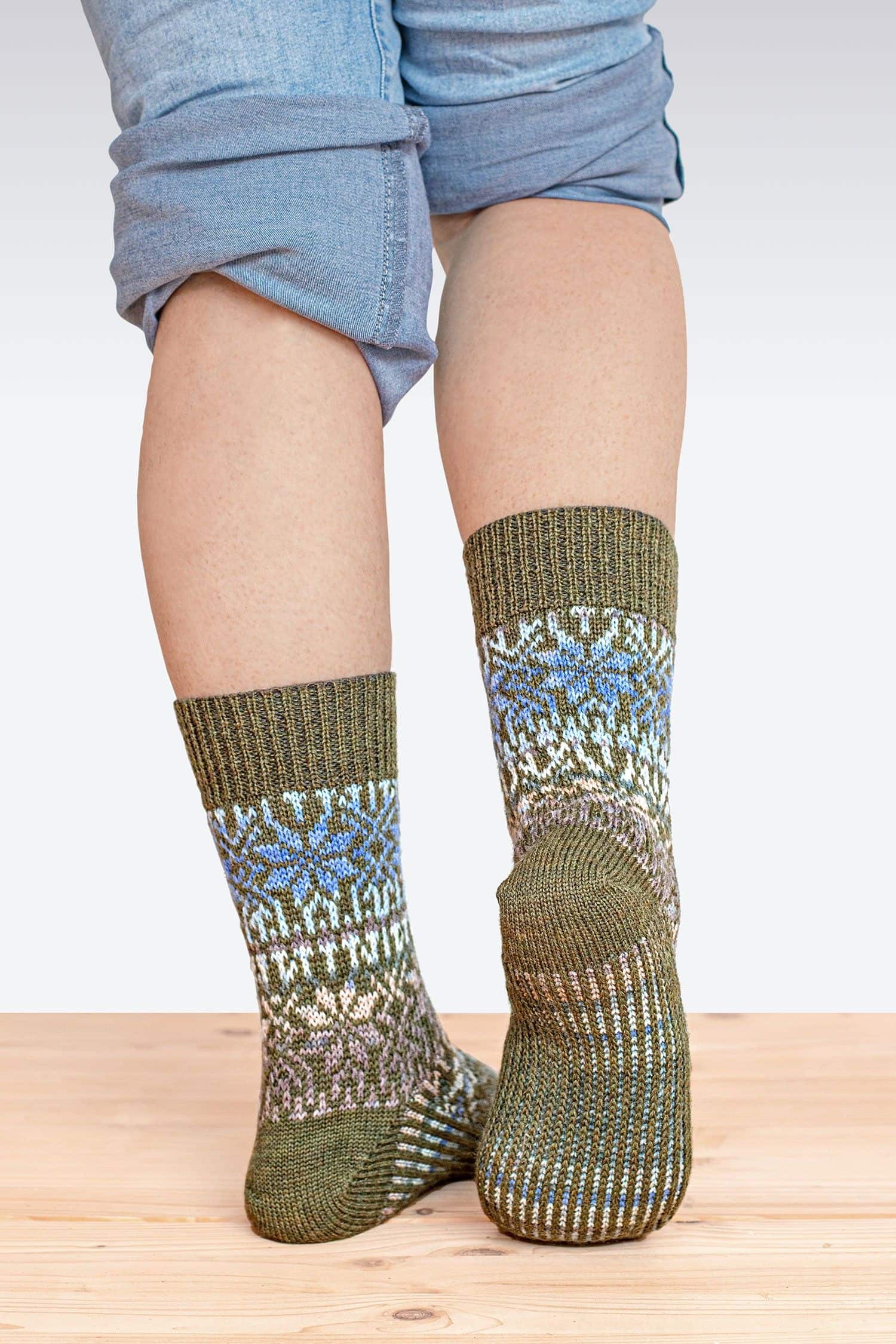Person mit hochgekrempelter Jeans trägt olivegrüne Norwegersocken aus bio Wolle (kbT), von hinten