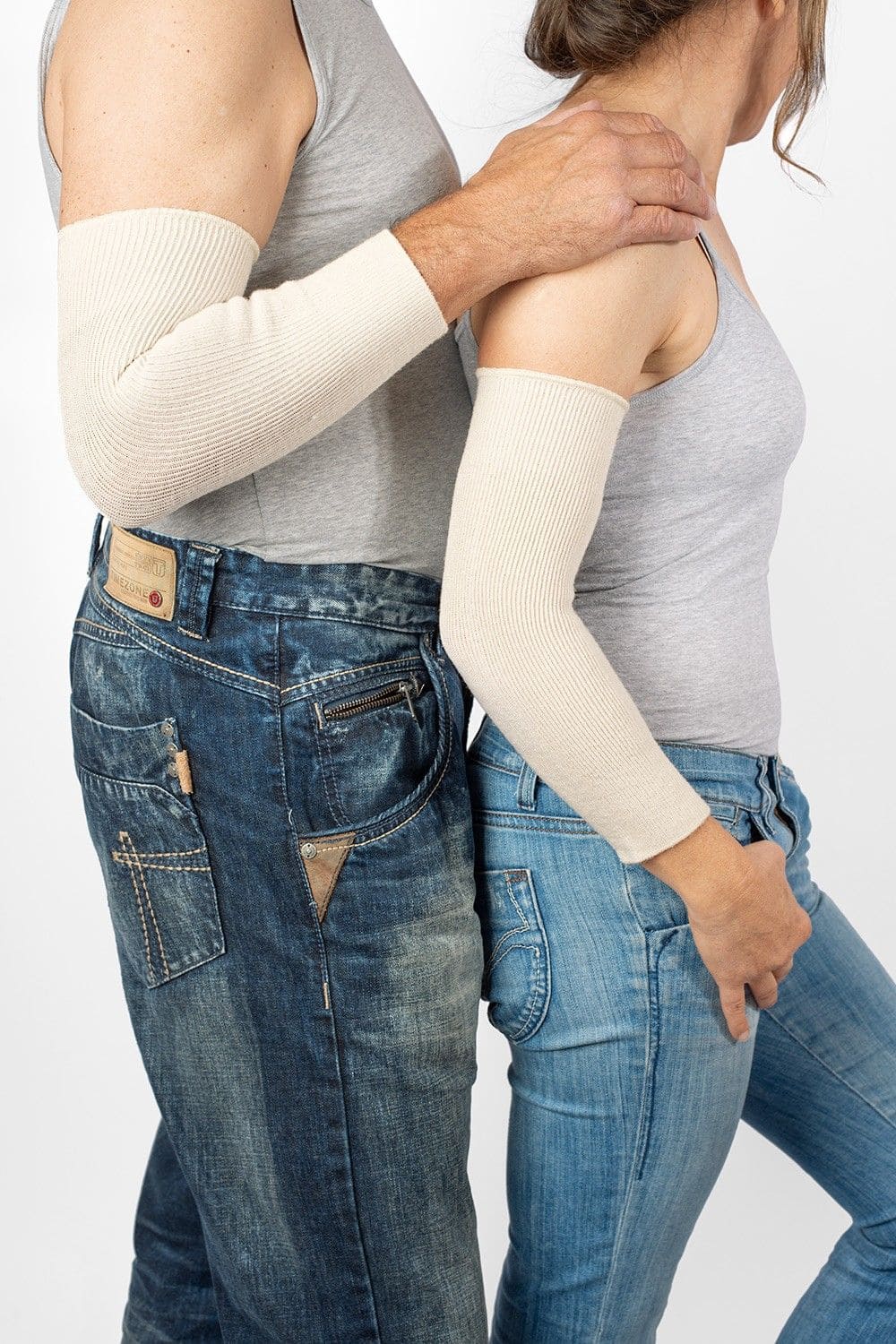 Models tragen Jeans, Top und naturweiße Ellbogenwärmer aus bio Wolle (kbT), Seide, Baumwolle und Elasthan