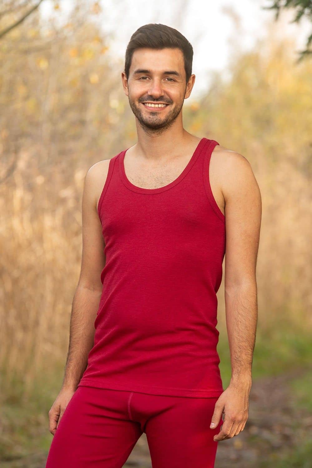 Mann trägt rotes Unterhemd aus bio Wolle (kbT) und eine lange Unterhose in rot