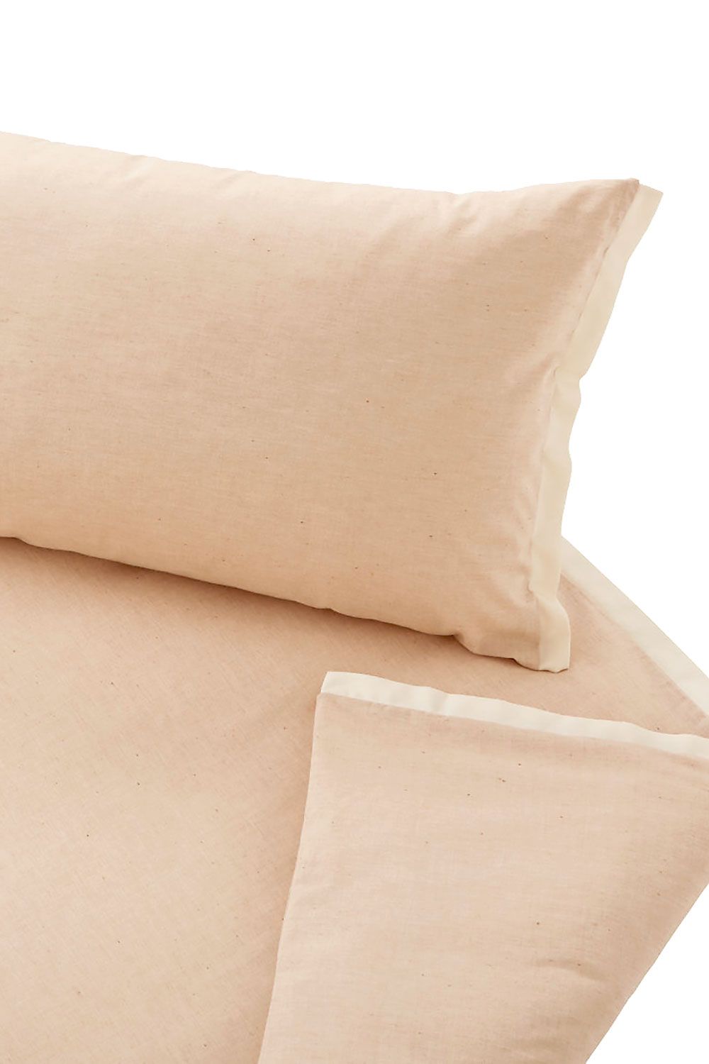 Nahaufnahme von ungefärbter Bettwäsche aus bio Baumwolle (kbA) auf weißem Untergrund