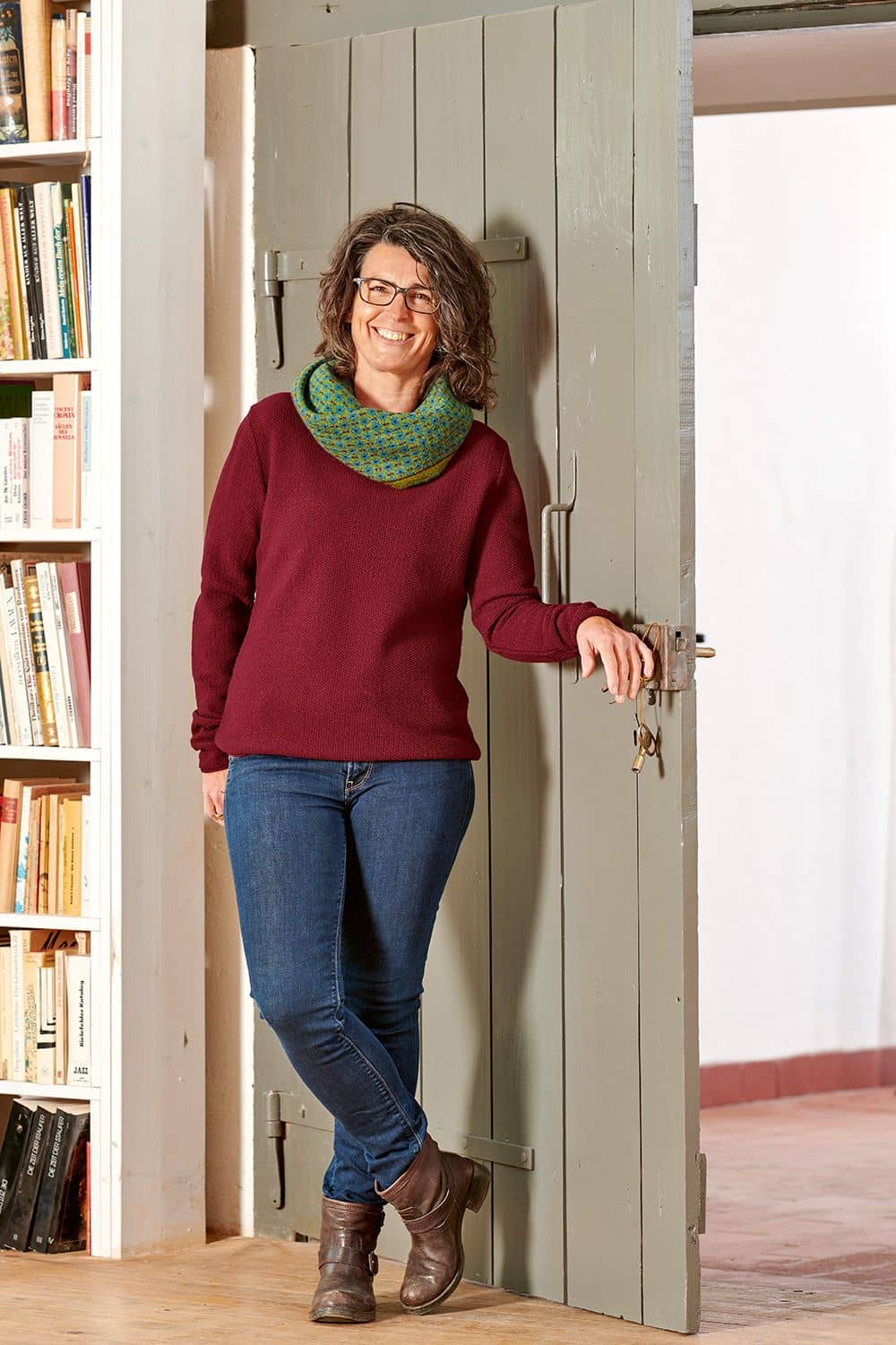 Frau mit Jeans und grün gemustertem Schal trägt bordeauxrotes Wollshirt aus bio Wolle (kbT) vom Finkhof