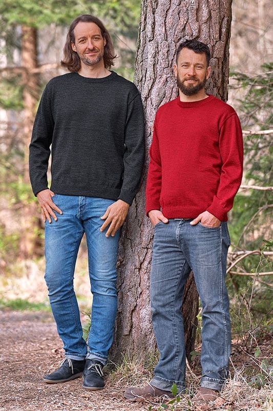 Rundhalspullover zwei Männer mit Jeans und Rundhalspullover aus bio Wolle (kbT) vom Finkhof in rot und weiß sind an Baum gelehnt